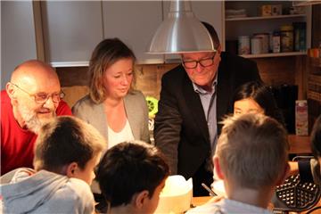 Jugendpfleger Jürgen Denker (von links), Erste Gemeinderätin Claudia Lühmann und Ortsvorsteher Herbert Lührs backen mit Kindern im neuen Jugendraum Waffeln. 
