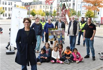 Junge Nutzer sitzen umringt von den Kräften, die auf dem Leher Pausenhof für Programm sorgen (von links): Nora Wieczorek und Miriam Gieseking (Quartiersmeisterei), Manfred Maas (AFZ-Umweltwächter), Bildungsbuddy Elisa Kriege, Cafer Isin (Quartiersmeisterei), Anwohner Wolf Truhart, Fanar Hamo (AFZ-Umweltwächter) und Bildungsbuddy Memet Özkisi.