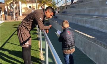 Justus Engel aus Düring zeigt einem Spieler des Fußball-Zweitligisten FC St. Pauli sein Malbuch.