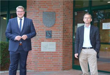 Henrik Wärner und Christian Grüter stehen am Wahlabend vor dem Schiffdorfer Rathaus. 