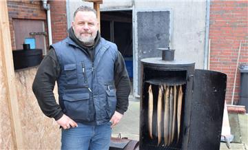 Kai Großmann vor seinem Smoker. Aal räuchert er über Eichenholz. Er bietet geräucherten und ungeräucherten Fisch an.
