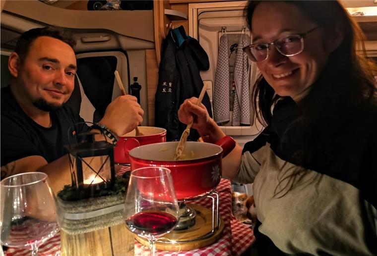 Andy Krüger und Tina Halbhuber aus Nordenham sitzen in ihrem Wohnmobil und essen Fondue.
