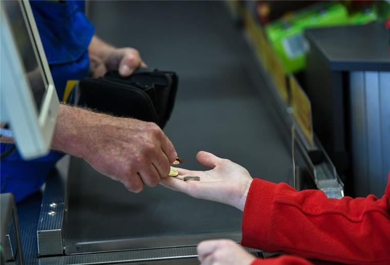 Sozialhilfeempfänger können keinen Inflationsausgleich einklagen An einer Supermarktkasse wird mit Kleingeld bezahlt.
