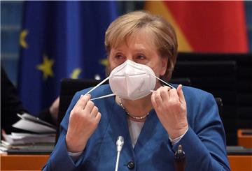 Bundeskanzlerin Angela Merkel (CDU) nimmt ihre Gesichtsmaske ab, bevor sie die wöchentliche Kabinettssitzung leitet. 