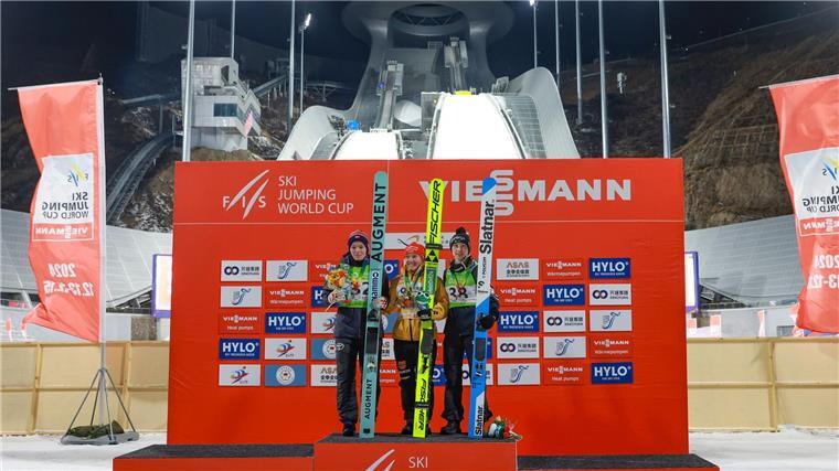 Katharina Schmid (M) bejubelt ihren Sieg auf der Olympia-Anlage.