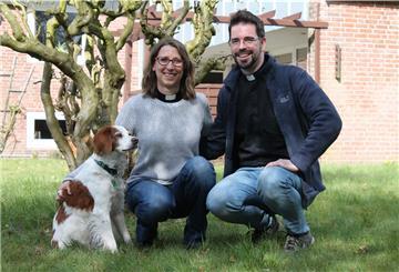 Katharina und Michael Behrens teilen sich seit dem 1. April die Pfarrstelle in der Ansgari-Kirchengemeinde Lunestedt. Hund „Clint“ fühlt sich im Pfarrgarten bereits pudelwohl.