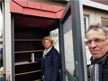 Kathrin Hantke und Bernd Pratsch stehen vor dem ausgeräumten Bücherschrank in der Kurfürstenstraße. 