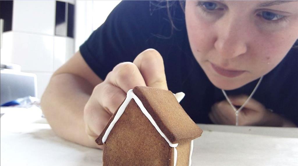 Katie verziert ihr Mini-Lebkuchenhaus.