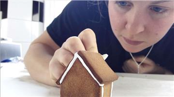 Katie verziert ihr Mini-Lebkuchenhaus.