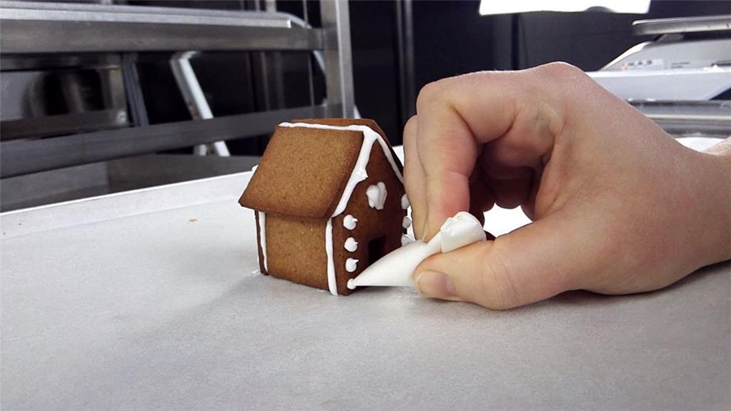Katie verziert ihr Mini-Lebkuchenhaus.