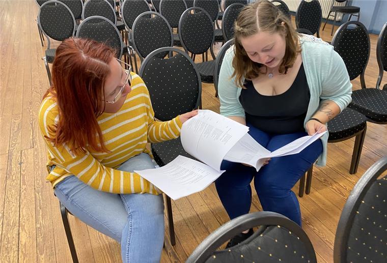 Katja Kramer (links) und Melissa Hattermann blättern durch das Songheft. 34 Lieder auf den 70er-Jahren gilt es auswendig zu lernen.