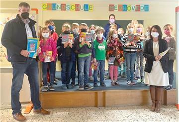 Katja Schulze (rechts) und Lars Behrje (links) vom Rotary Club Hagen übergeben die Bücher an die Schülerinnen und Schüler an der Grundschule Bexhövede. Dabei wurden fünf Schulklassen bedacht. 