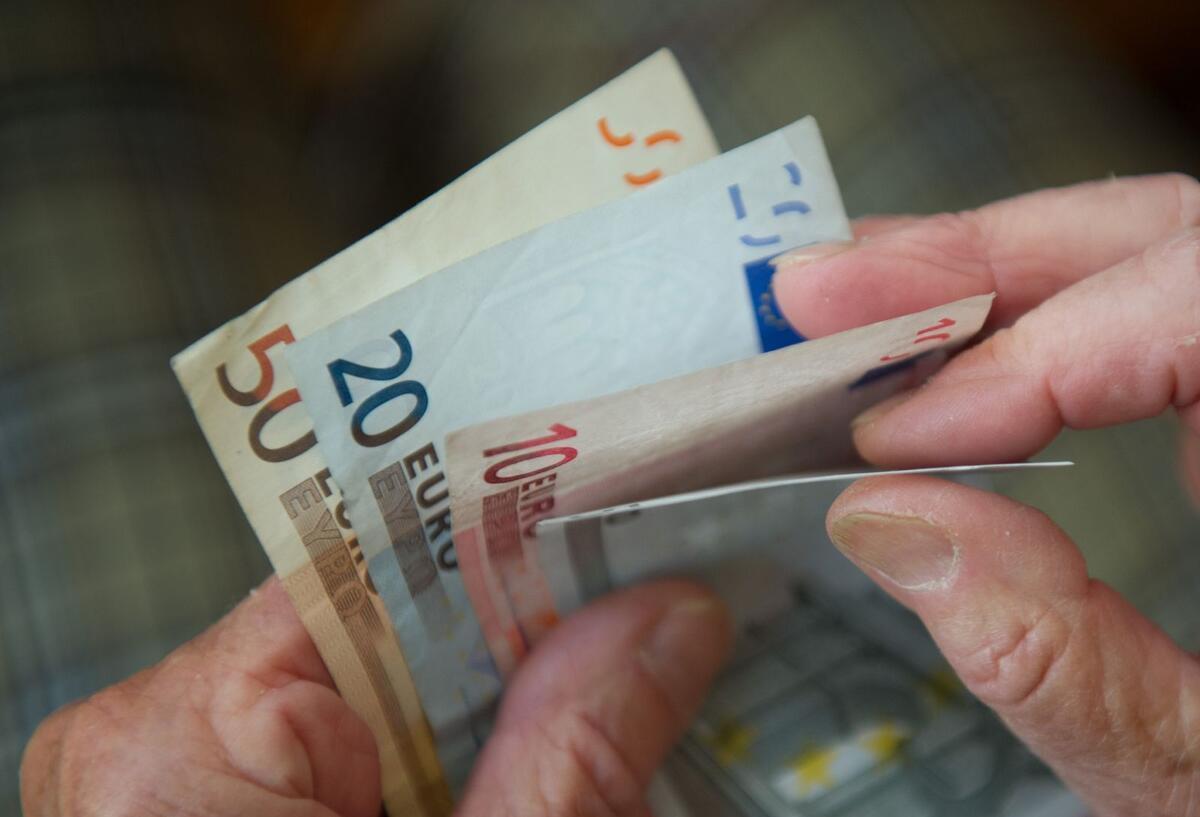 Mehr Geld im Portemonnaie: Tipps für kluge Budgetplanung Zwei Hände halten ein paar Geldscheine und zählen sie.