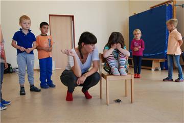 Kinder der Kita Regenbogen in Schiffdorf bei ersten Schauspielübungen: Marie Sophie sitzt auf dem Stuhl und  ist die Königin,  die auf  die Kronjuwelen unter  ihrem Thron aufpassen soll. Theaterpädagogin Katharina Dürr erklärt das Spiel, bei dem die anderen Kinder zu Juwelenräubern werden.   