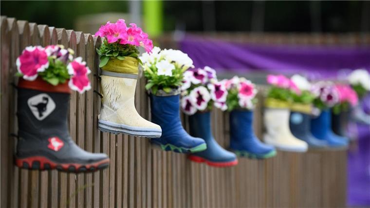 Kitas im Krisenmodus: Konferenz sucht Lösungen Kinder-Gummistiefel mit Blumen hängen an einem Zaun einer Kindertagesstätte.