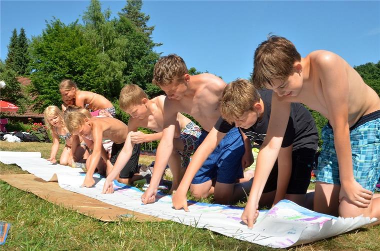 Kinder und Jugendliche dokumentieren per Daumenabdruck auf einem Protestplakat, dass ihnen das Freibad in Kirchtimke wichtig ist. 