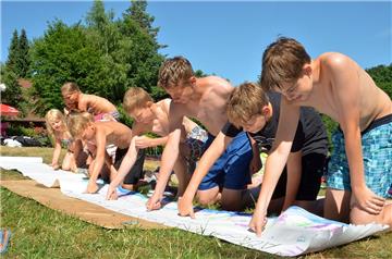 Kinder und Jugendliche dokumentieren per Daumenabdruck auf einem Protestplakat, dass ihnen das Freibad in Kirchtimke wichtig ist. 