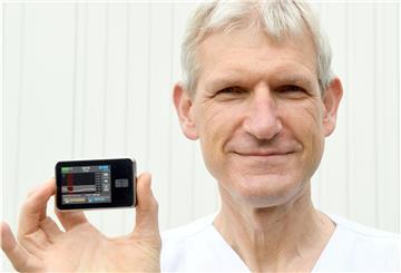 Kinderarzt und Diabetologe Dr. Holger Baaske zeigt eine moderne Insulinpumpe, die über einen Katheter unter der Haut automatisch und je nach Blutzuckerwert Insulin zuführt.