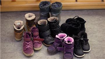 Kinderschuhe stehen in einer Kita in der Garderobe auf dem Boden.