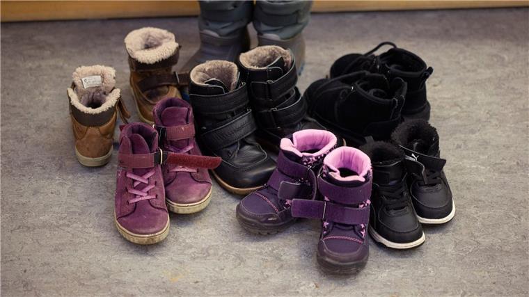 Im Land Bremen brennt es bei den Betreuungsplätzen für Kinder Kinderschuhe und -stiefel sind auf dem Boden in einer Kindertagesstätte abgestellt.