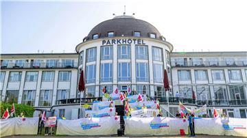 Kita-Beschäftigte stehen mit Fahnen vor dem Hotel, in dem die Familienministerkonferenz stattfindet.