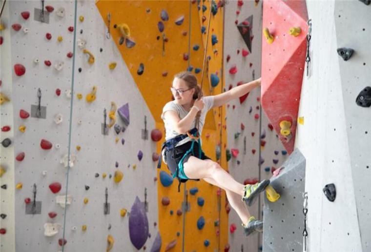 Junge Frau an einer Bowlderwand