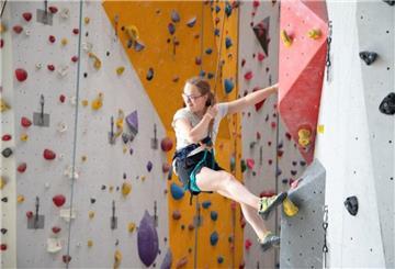 Junge Frau an einer Bowlderwand