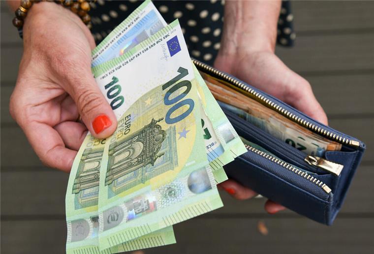 Doch kein Klimageld! Was jetzt aus den versprochenen 1000 Euro pro Familie wird Eine Frau hält eine Geldbörse in der einen und mehrere 100-Euro-Scheine in der anderen Hand. Das Klimageld versprach bis zu 1000 Euro pro Familie, doch nun kommt es doch nicht.