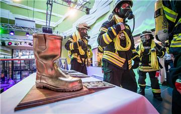 Klimahauslauf 2019. Bereits am Nachmittag starteteten zum ersten Firefighter-Rescue-Run Feuerwehrleute in voller Montur zum Lauf über 1,2 Kilometer durchs Haus. Im Bild: Als Siegertrophäe gibt es einen goldenen Stiefel für den besten Läufer. 