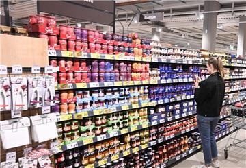 Eine Kundin geht in einer Filiale des Lebensmittelhändlers Kaufland durch eine Reihe mit Lebensmitteln.
