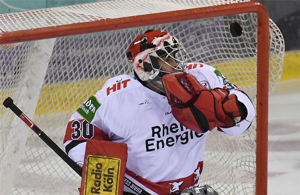 Kölns Torhüter Daniar Dshunussow kann den Puck nicht fangen und wird schon nach ...