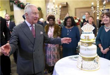 König Charles steht am Vorabend seines 75. Geburtstages in Highgrove neben seiner Geburtstagstorte.