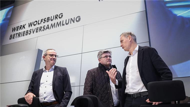 Konzernchef Oliver Blume (r.) berät sich vor seiner Rede mit  VW-Verhandlungsführer Arne Meiswinke (Mitte).