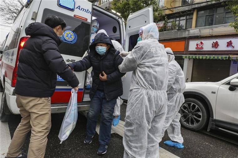 Schon 80 Tote: Zahl der Virus-Infizierten in China steigt sprunghaft Krankenhausmitarbeiter in Schutzkleidung helfen einem Patienten in Wuhan aus einem Krankenwagen. Angesichts der starken Ausbreitung der neuen Lungenkrankheit hat China seine Maßnahmen am Wochenende deutlich verschärft.