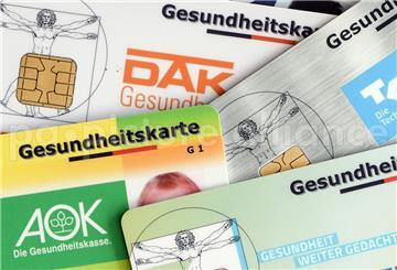 Viele Versicherungskarten von Krankenkassen liegen übereinander.