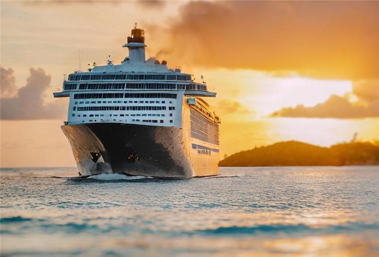 Ein Kreuzfahrtschiff fährt in den Sonnenuntergang.