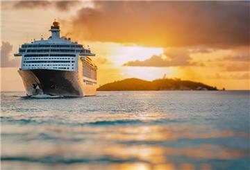 Ein Kreuzfahrtschiff fährt von einer Insel in Richtung des offenen Meers. 