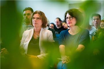 Kristina Vogt (l) und Claudia Bernhard, beide Mitglieder in der Bremischen Bürgerschaft für die Partei Die Linke, sitzen während des Landesparteitags der Partei Die Linke in einem Saal. 
