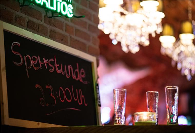 Niedersachsen: Gericht kippt Sperrstunde Kurz vor der Sperrstunde stehen neben einem Kreideschild mit der Aufschrift: „Sperrstunde 23:00 Uhr" drei leere Gläser Bier auf einem Tisch.