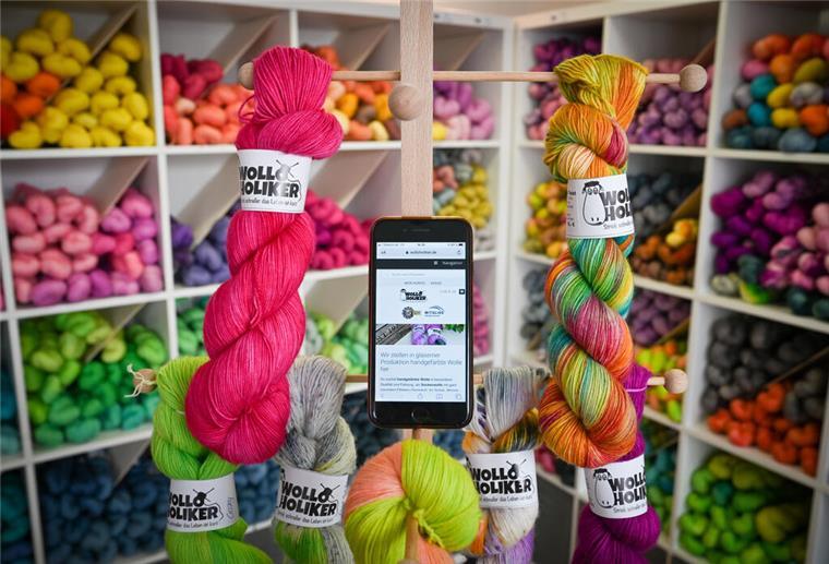Wolle und ein Smartphone sind im Ladengeschäft von "Wolloholiker" aufgebaut.