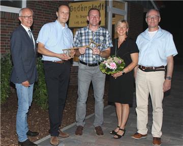 Landrat Hermann Luttmann (von links), Architekt Marco von Bargen, Bürgermeister Harald Hauschild, Dorfvereins-Vorsitzende Alexandra Martens und Samtgemeindebürgermeister Gerhard Kahrs nach der Schlüsselübergabe vor nostalgischem Ortsschild am Dorfgemeinschaftshaus.  