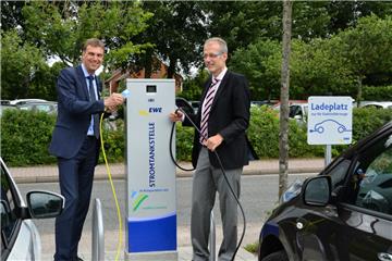 Landrat Kai-Uwe Bielefeld (links) und Thomas Windgassen, Leiter Geschäftsregion Cuxhaven/Delmenhorst bei EWE, nahmen am Montag die neue Stromtankstelle am Kreishaus in Betrieb.