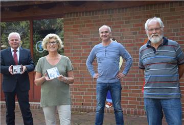 Landrat Thomas Brückmann (von links), Anne Allmers, Vorsitzende des Kinderschutzbundes Nordenham, Autor und Schauspieler René Schack sowie der Plattdeutschbeauftragte des Landkreies Wesermarsch Hans Meinen freuen sich über die DVD "De lütte Zoogeschicht".