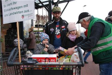 Landvolk-Mitarbeiter Arno Müller aus Schiffdorf erläutert den Bürgern in Hagen, dass die heimische Landwirtschaft an vielen Produkten des täglichen Einkaufs beteiligt ist. Auch Alex Klein aus Wulsbüttel sowie Sohn Lias (links) und  Tochter Danica hören aufmerksam zu. 
