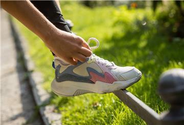 Ein Laufschuh wird zugeschnürt.