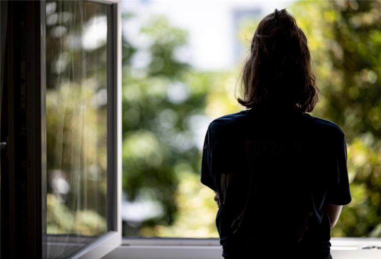 Eine Frau steht in ihrer Wohnung an einem Fenster. Baden-Württemberg verzeichnet nach Angaben der Krankenkasse KKH den bundesweit höchsten Anstieg an wiederholt an Depressionen erkrankten Menschen (Gestellte Szene - zu dpa: «KKH-Daten: Im Südwesten bundesweit größter Anstieg bei Depressionen») +++ dpa-Bildfunk +++