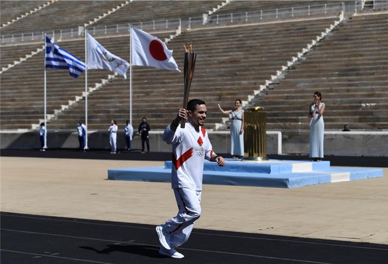 Lefteris Petrounias, griechischer Olympiasieger im Kunstturnen, läuft mit der Fackel während der Übergabe des olympischen Feuers an die Organisatoren der Sommerspiele von Tokio 2020. 