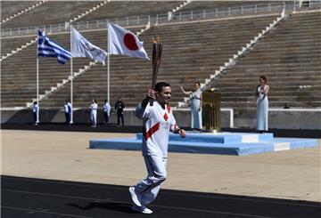 Lefteris Petrounias, griechischer Olympiasieger im Kunstturnen, läuft mit der Fackel während der Übergabe des olympischen Feuers an die Organisatoren der Sommerspiele von Tokio 2020. 