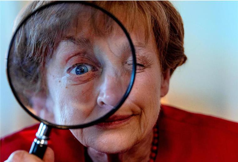 Ozeanriese „Mein Schiff 5“ wird Schauplatz für einen neuen Kreuzfahrt-Krimi Schauspielerin Katharina Thalbach verkleidet als Miss Merkel schaut mit einem Auge durch eine Lupe
