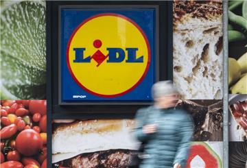 Eine Passantin geht an der Außenwerbung einer Lidl-Filiale vorbei.